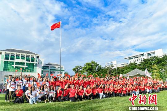 9月2日，beat365唯一官网，学生们在入学升国旗仪式结束后与国旗合影。　陈骥旻 摄